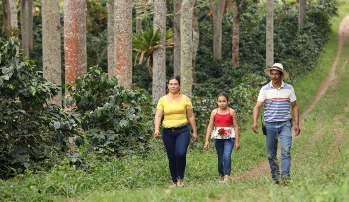 mujer, niña y hombre caminando en el campo